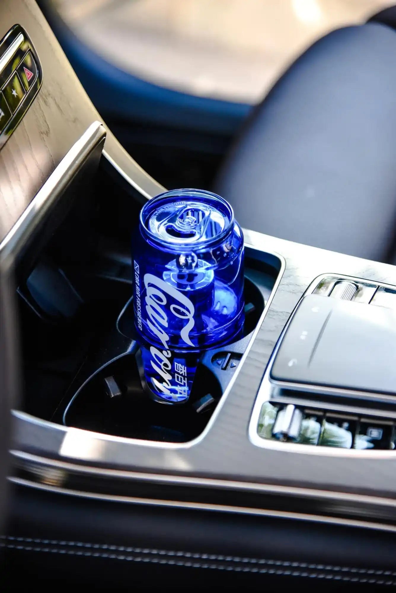 A clear blue Coca-Cola can-shaped drinking glass.