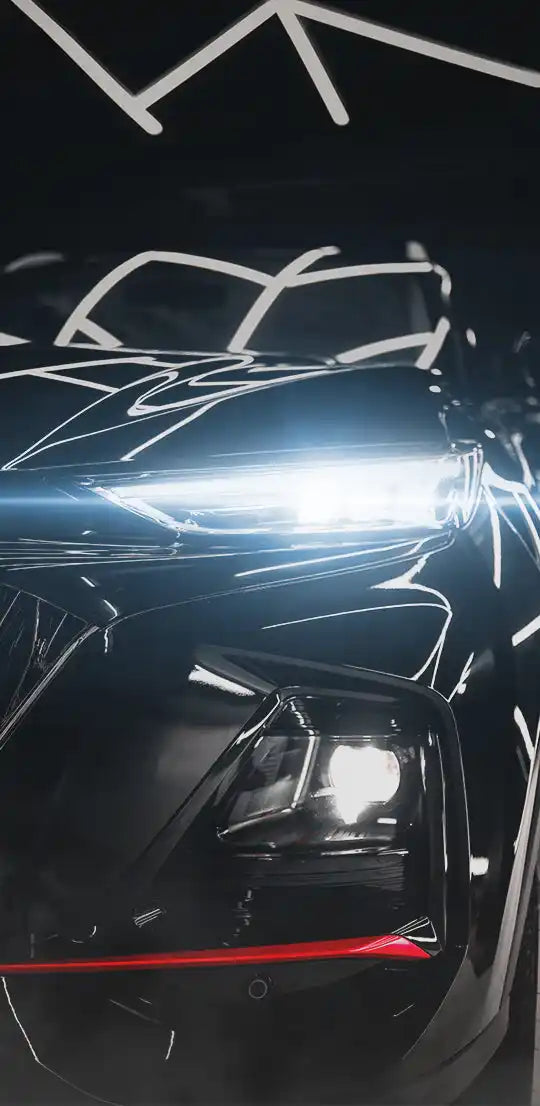 Sleek, black car with bright, futuristic headlights and a red accent bar.